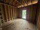 Bedroom framing highlights the window placement, wall studs, and subfloor ready for customization at 5021 Mitchell Town Rd, Youngsville, NC 27596