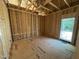 Unfinished bedroom showing wood framing with a large window during the construction phase at 5021 Mitchell Town Rd, Youngsville, NC 27596