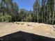 View of a construction site with a cleared lot ready for landscaping, and trees in the background at 5021 Mitchell Town Rd, Youngsville, NC 27596