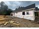 Exterior shot of the house under construction featuring framing and material delivery, with a dark roof at 5021 Mitchell Town Rd, Youngsville, NC 27596