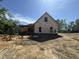 Exterior view of a home under construction with visible weather barrier and framed openings for doors and windows at 5021 Mitchell Town Rd, Youngsville, NC 27596