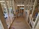 Unfinished hallway showing wood framing, and a staircase during the construction phase at 5021 Mitchell Town Rd, Youngsville, NC 27596