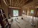 Framed living room highlighting natural light from windows, wall studs, and subfloor ready for finishes at 5021 Mitchell Town Rd, Youngsville, NC 27596