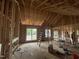 Framed living room shows exposed beams, and multiple window and door frames for plenty of natural light at 5021 Mitchell Town Rd, Youngsville, NC 27596