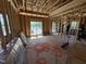 Unfinished living room showing wood framing, and a large window during the construction phase at 5021 Mitchell Town Rd, Youngsville, NC 27596