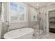 Luxurious bathroom with a soaking tub, walk-in shower, and stylish gray tilework at 512 Montague Ln, Raleigh, NC 27601