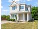 Inviting two-story home boasts a covered porch, a well-kept lawn, and modern architectural details at 512 Montague Ln, Raleigh, NC 27601