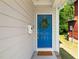 Close-up of a charming blue front door adorned with a wreath and a 'Welcome' doormat at 512 Montague Ln, Raleigh, NC 27601