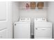 Clean laundry room features two white appliances and a wire shelf with baskets for storage at 517 Fife Ct, Gibsonville, NC 27249