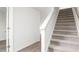 Bright hallway with carpeted stairs, white walls, and elegant wood-look flooring at 525 Lochalsh Dr, Gibsonville, NC 27249