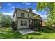 Backyard view showing the two-story house with a screened porch, brick accents, and an American flag at 5600 Bennettwood Ct, Raleigh, NC 27612