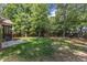 Spacious backyard featuring lush green grass, mature trees, and a wooden fence for privacy at 5600 Bennettwood Ct, Raleigh, NC 27612