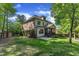 Backyard view of the home with lush landscaping and a screened porch at 5600 Bennettwood Ct, Raleigh, NC 27612