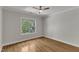 This bedroom features hardwood floors, large window, ceiling fan, and neutral paint at 5600 Bennettwood Ct, Raleigh, NC 27612