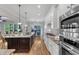 Modern kitchen with stainless steel appliances, white cabinets and view into living area at 5600 Bennettwood Ct, Raleigh, NC 27612
