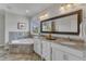 Elegant bathroom featuring a tub, double vanity with granite countertops, and vanity lighting at 5600 Bennettwood Ct, Raleigh, NC 27612