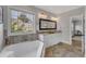 Bathroom featuring a soaking tub, double vanity with granite countertops, and luxury lighting at 5600 Bennettwood Ct, Raleigh, NC 27612