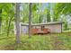 Backyard view with a deck, grassy area, and bordered by mature trees at 5613 Deerborn Dr, Apex, NC 27539