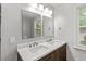 Bright bathroom with double sink vanity, quartz countertops and stylish mirrors at 5613 Deerborn Dr, Apex, NC 27539