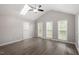 Vaulted ceiling bedroom features skylight, three windows, ceiling fan, and vinyl flooring at 5613 Deerborn Dr, Apex, NC 27539