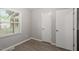 Bedroom features vinyl flooring, closet, and window illuminating the gray walls at 5613 Deerborn Dr, Apex, NC 27539