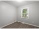 Neutral bedroom features vinyl flooring and a window bringing natural light to the space at 5613 Deerborn Dr, Apex, NC 27539