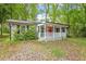 Inviting single-story home featuring a covered front porch, complemented by lush green surroundings at 5613 Deerborn Dr, Apex, NC 27539