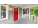 Close up view of the front porch with a vibrant red front door and stylish exterior lighting at 5613 Deerborn Dr, Apex, NC 27539