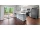 Modern kitchen featuring stainless steel appliances, granite countertops, and sliding door access to the deck at 5613 Deerborn Dr, Apex, NC 27539