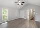 Vaulted ceiling bedroom with ceiling fan, large windows, and an open doorway to the bathroom at 5613 Deerborn Dr, Apex, NC 27539
