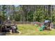 The fenced backyard offers a large, well-maintained lawn with a wooden deck and a play set at 60 Northdale Ct, Louisburg, NC 27549