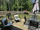 Outdoor deck featuring stylish furniture, a patio umbrella and wooded backdrop at 60 Northdale Ct, Louisburg, NC 27549
