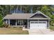 Charming home featuring a covered front porch with landscaping and an attached two-car garage at 60 Northdale Ct, Louisburg, NC 27549