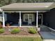 Cozy front porch with rocking chairs and stone accents, enhanced by a landscaped flower bed at 60 Northdale Ct, Louisburg, NC 27549
