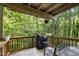 A wooden balcony with outdoor seating and a grill covered from the elements offers a relaxing outdoor space at 629 Pine Ridge Pl, Raleigh, NC 27609