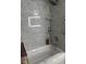 This bathroom features a shower/tub with gray marbled tile, corner shelving, and a built-in niche for toiletries at 629 Pine Ridge Pl, Raleigh, NC 27609