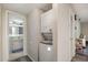 A hallway with a stacked washer/dryer, and an open door to a marble-countered bathroom, offers convenience and accessibility at 629 Pine Ridge Pl, Raleigh, NC 27609