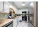 Well-lit kitchen featuring stainless steel appliances and sleek white cabinetry at 629 Pine Ridge Pl, Raleigh, NC 27609