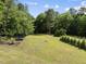Lush backyard featuring mature trees and a trampoline at 7116 Incline Dr, Wake Forest, NC 27587