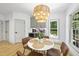 Cozy dining area featuring a modern chandelier and views of the landscaped backyard at 7116 Incline Dr, Wake Forest, NC 27587