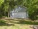Detached two-car garage surrounded by mature trees and lush landscaping at 7116 Incline Dr, Wake Forest, NC 27587