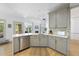 Charming kitchen showcasing gray cabinets, stainless appliances, stone countertops and backsplash, and wood floors at 7116 Incline Dr, Wake Forest, NC 27587