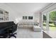 Cozy living room with comfortable seating, large windows, and a black piano, perfect for relaxation at 7116 Incline Dr, Wake Forest, NC 27587