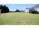 Large, green backyard with an expansive lawn, white home, deck, wooden fence and plenty of room to play at 74 Pedernales Dr, Smithfield, NC 27577