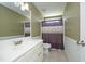 This bathroom features a single sink vanity, framed mirror and a toilet behind a purple shower curtain at 74 Pedernales Dr, Smithfield, NC 27577