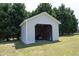 Open shed with an orange riding lawnmower sitting inside on a sunny day with a grassy lawn at 74 Pedernales Dr, Smithfield, NC 27577