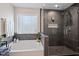 A luxurious bathroom features a soaking tub and a glass-enclosed shower, offering a spa-like experience at home at 7729 Calcutta Dr, Willow Springs, NC 27592