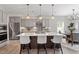 Modern kitchen featuring stainless steel appliances, a center island with seating, and gray cabinetry at 7729 Calcutta Dr, Willow Springs, NC 27592