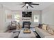 Cozy living room with a fireplace, comfortable seating, and a modern ceiling fan, great for relaxing at 7729 Calcutta Dr, Willow Springs, NC 27592
