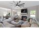 Cozy living room featuring a fireplace, large sectional couch, and ceiling fan at 7729 Calcutta Dr, Willow Springs, NC 27592